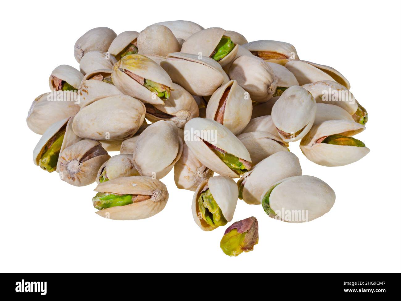 Closeup of roasted salted pistachios pile isolated on a white background. Pistacia vera. Yummy green pistachio cores in beige open split halved shells. Stock Photo