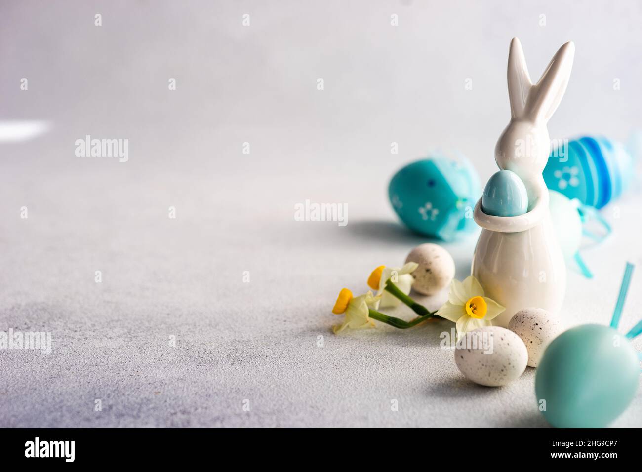 Painted Easter egg and Easter bunny decorations on a table with narcissus flower Stock Photo