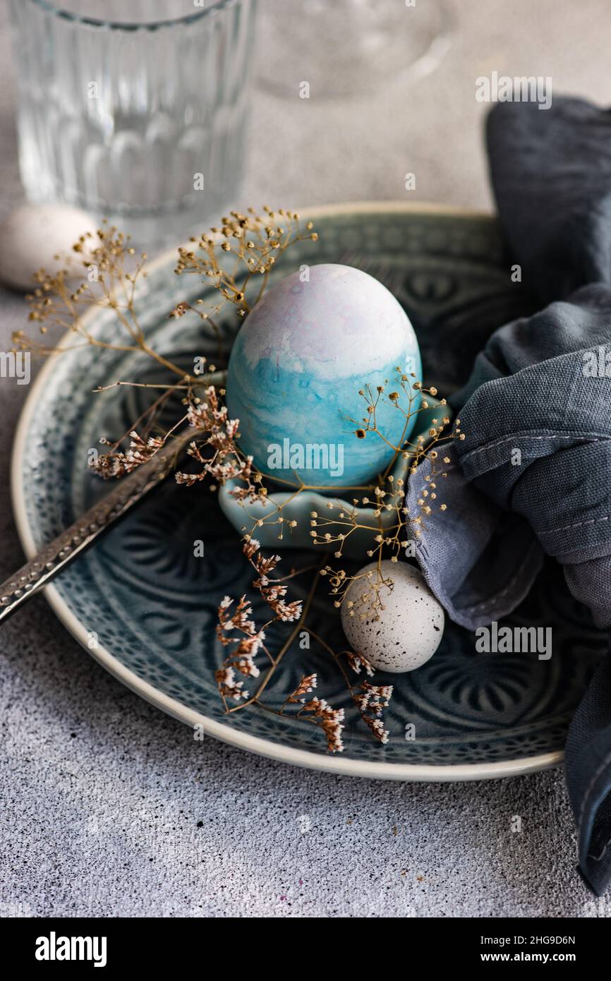 Festive Easter place setting with painted Easter eggs and dried flowers Stock Photo