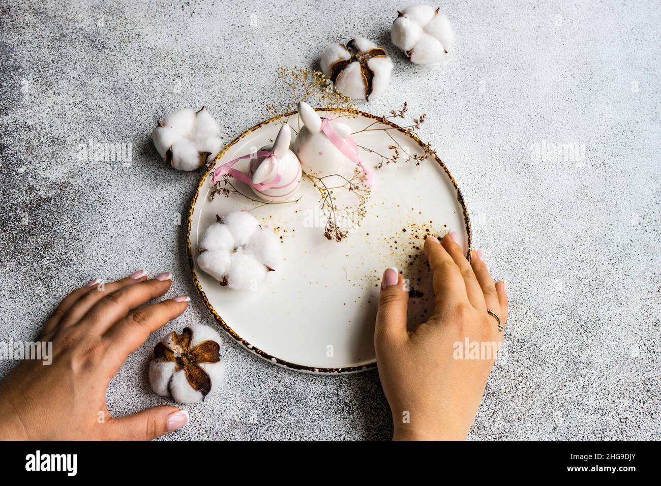 Overhead view of a woman setting a table with Easter decorations Stock Photo
