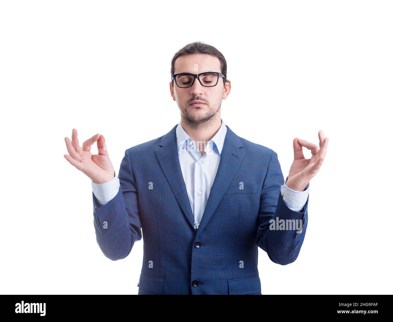 Relaxed businessman meditating as keeps eyes closed holds fingers in