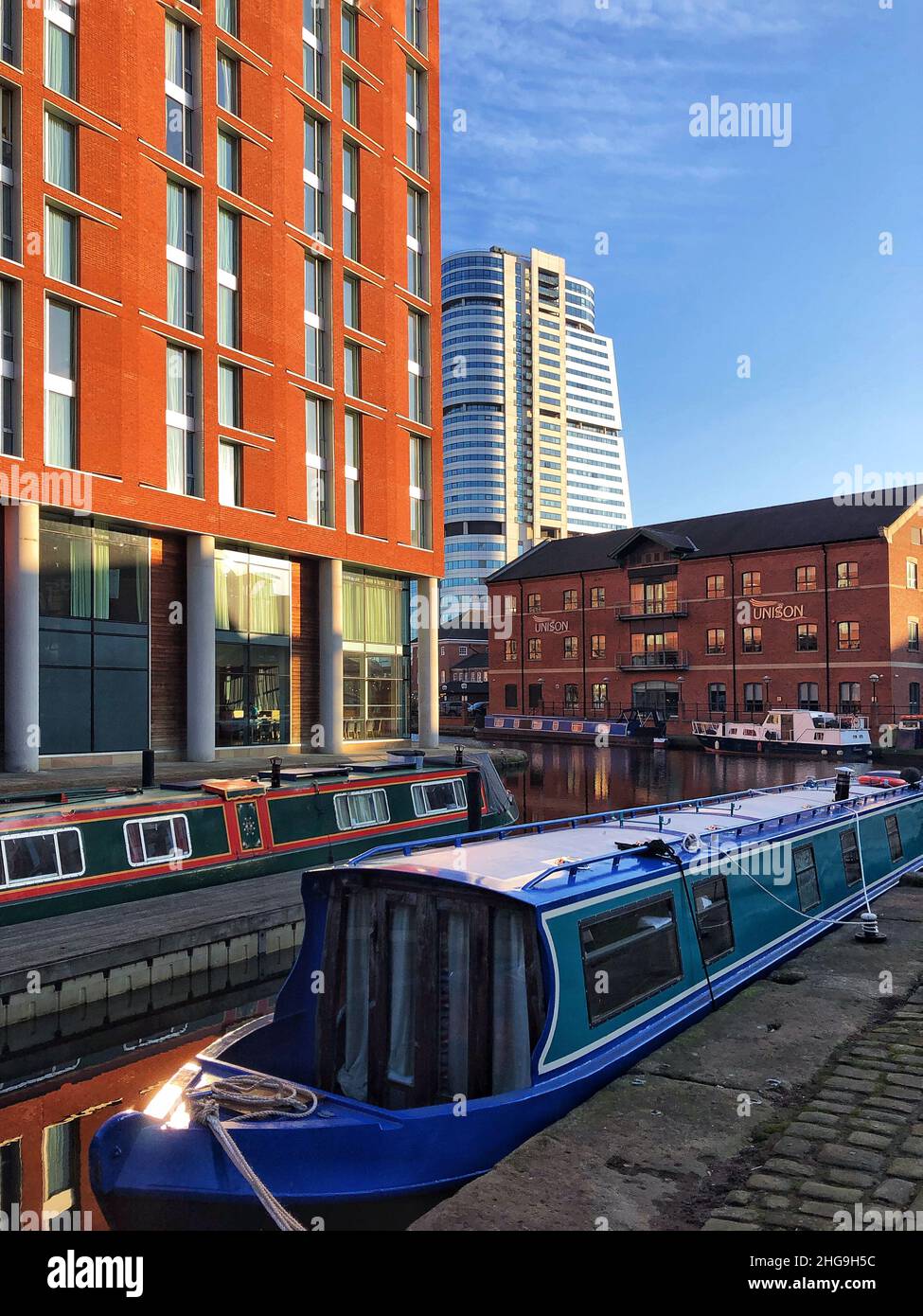 Barges and boats floating on the a river Aire in a Leeds city skyline ...