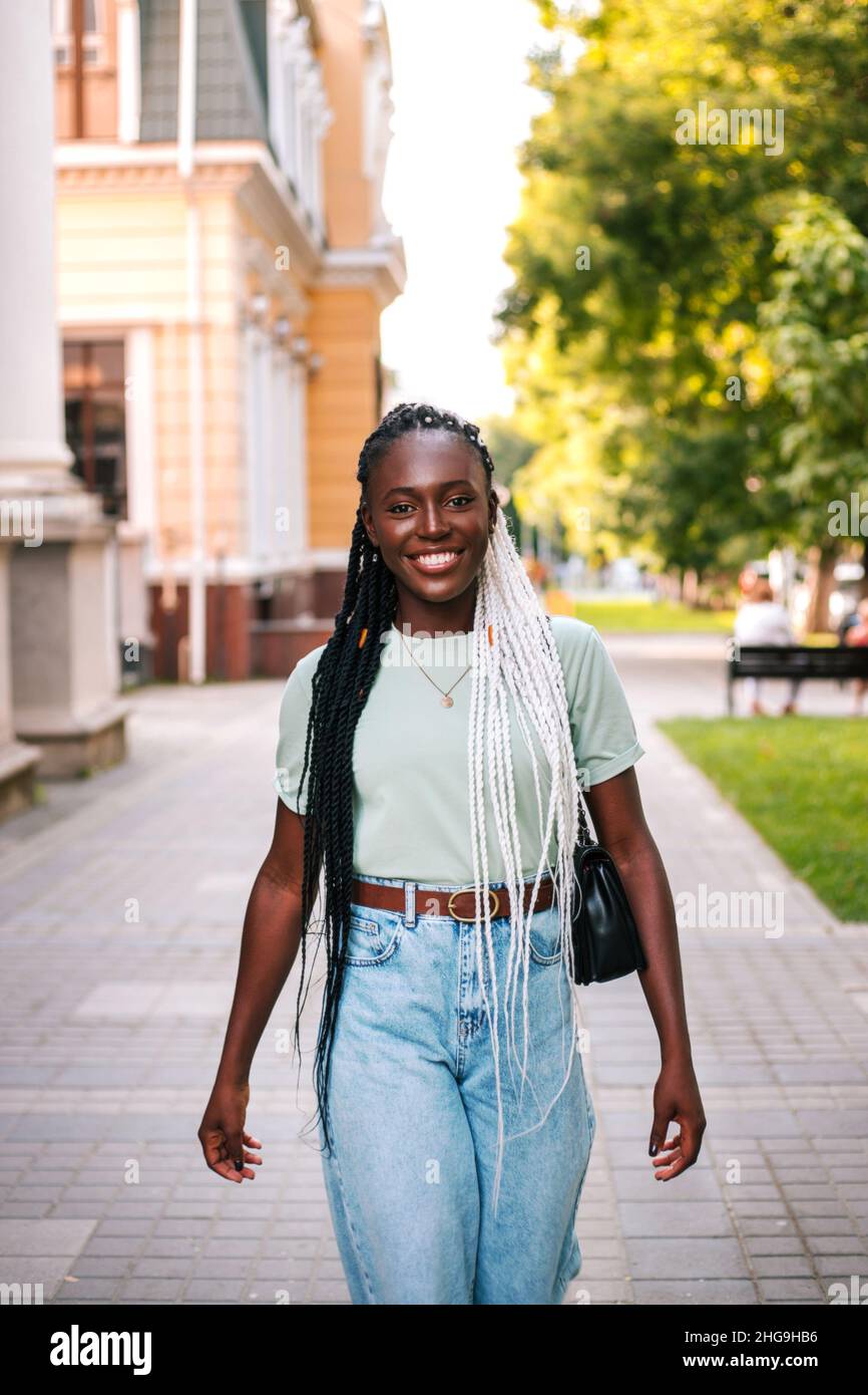 Beautiful young black woman walking at street Stock Photo - Alamy