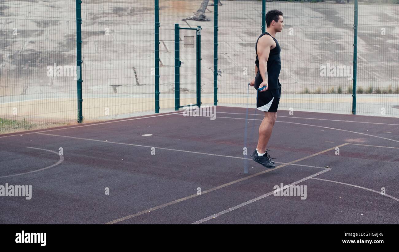 full length view of mixed race man jumping with skipping rope at outdoors gym,stock image Stock Photo