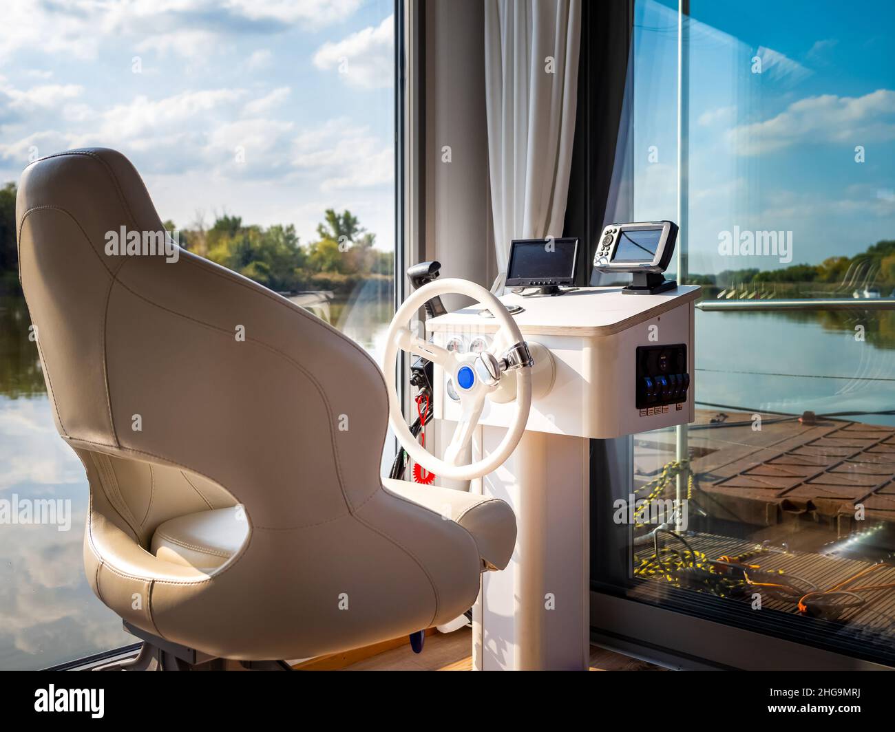 steering wheel and driver seat on houseboat or floating house on a river, close up view Stock Photo