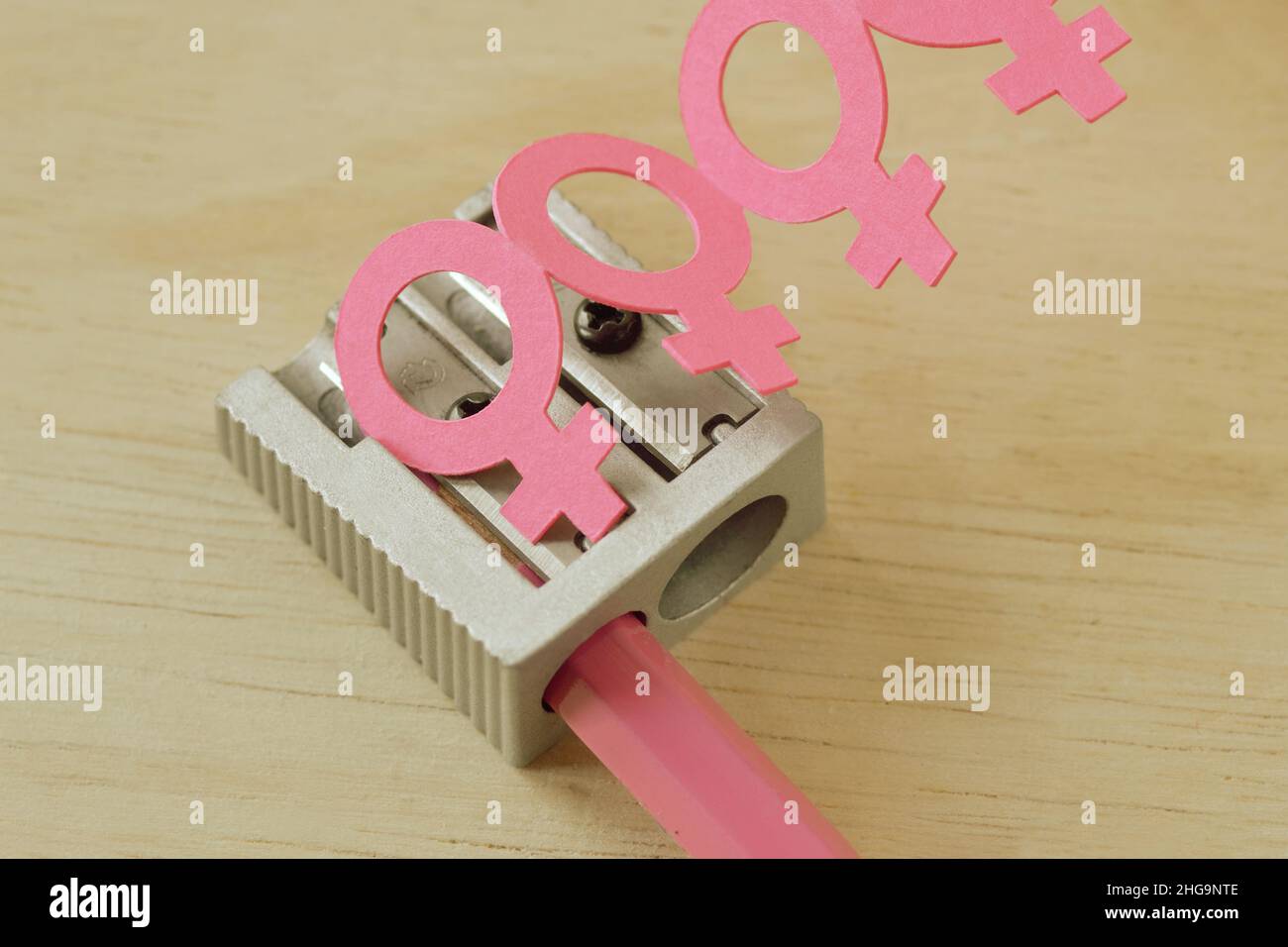 Sharpener and pink pencil with female gender symbol chain - Concept of women and creative thinking Stock Photo
