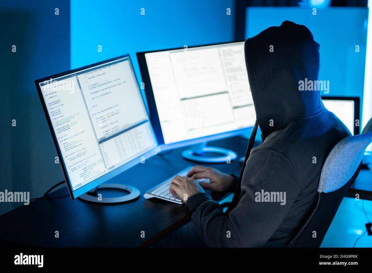 Hacker Using Computer To Write Cyber Security Exploit Software Program Stock Photo