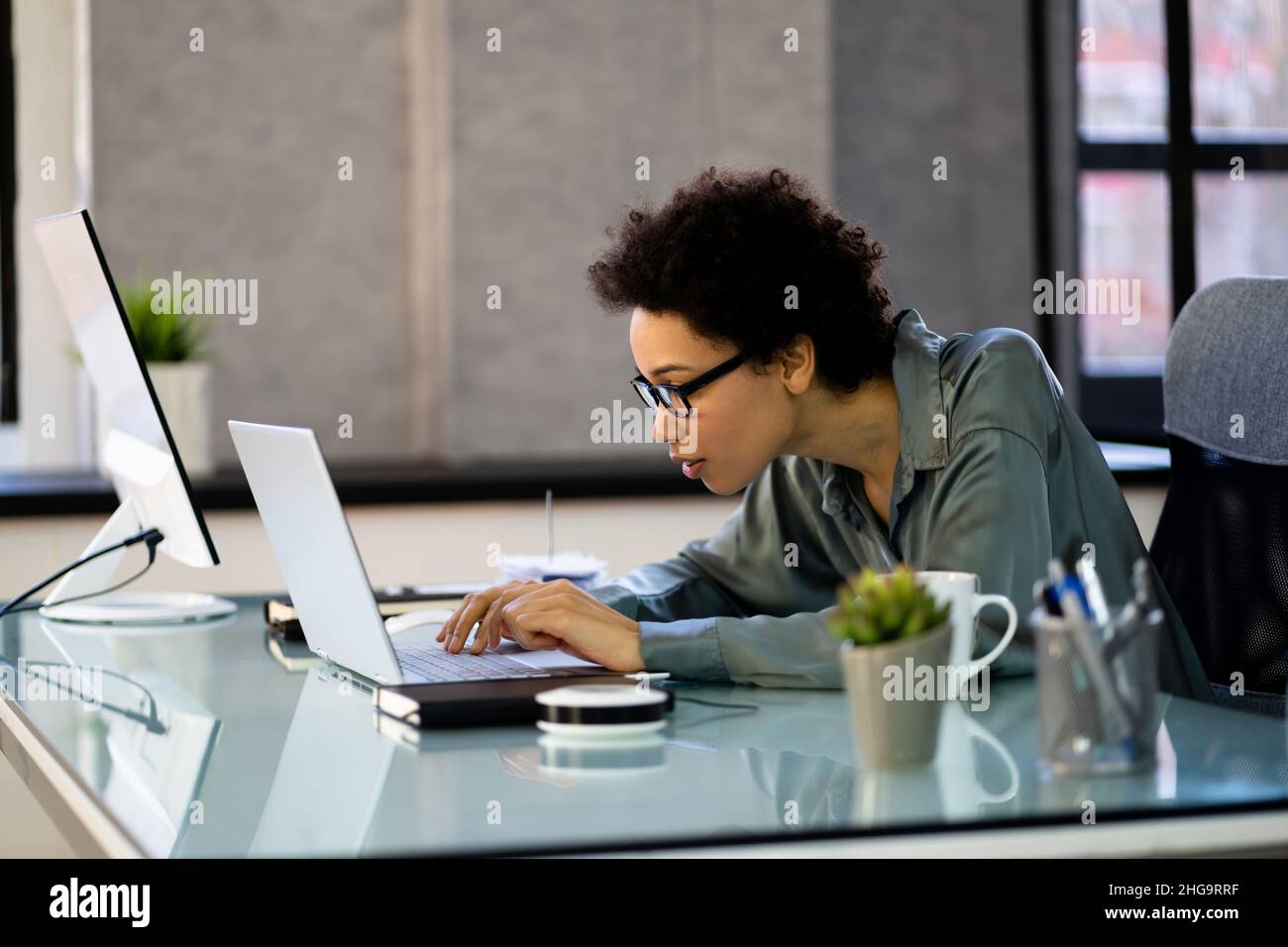 African Woman Bad Posture Working Typing At Desk Stock Photo