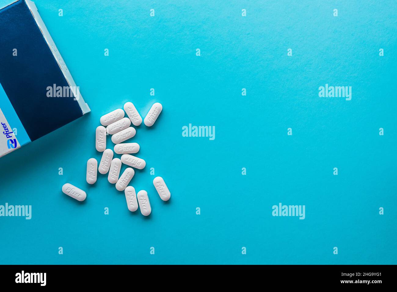 Izmir, Turkey -  November 5 2021: Pfizer Covid-19 Paxlovid treatment box and pills isolated on a blue background. Stock Photo