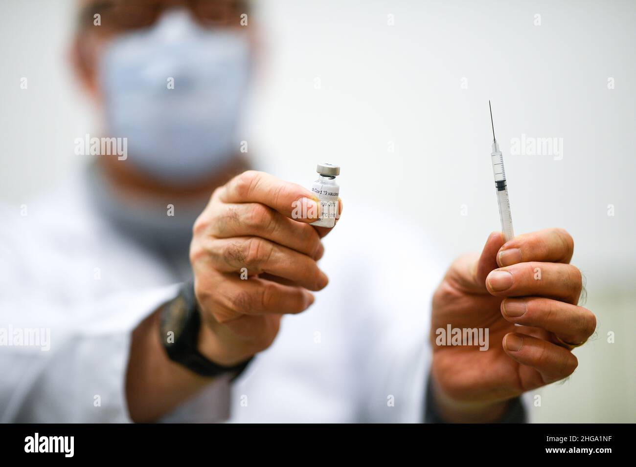 Illustration picture shows a general practitioner practicing vaccination in his office, holds a vial (BioNTech, Pfizer) and a syringe with the vaccine Stock Photo
