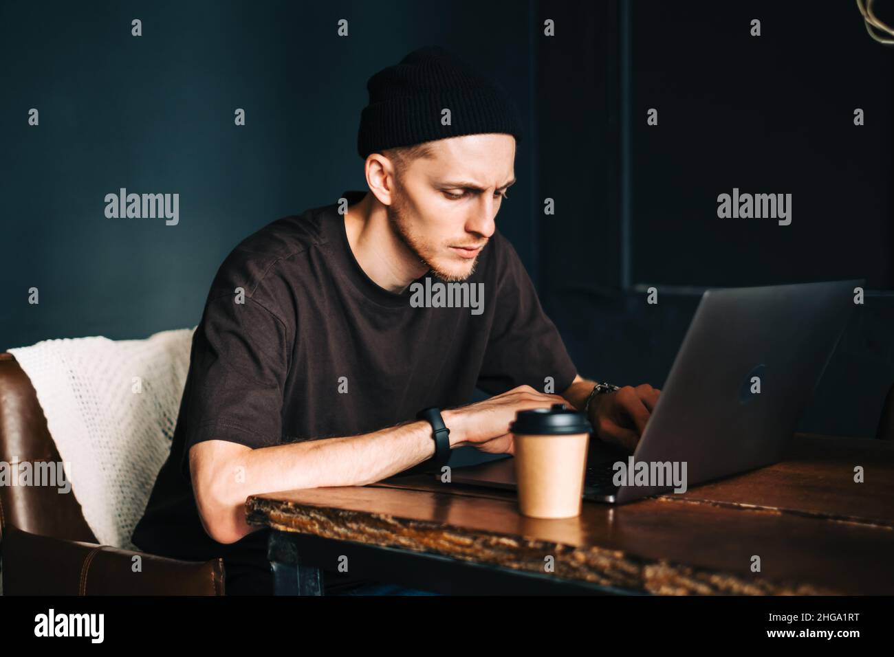 Young man mobile developer writes program code on a computer, programmer work in home office. Stock Photo