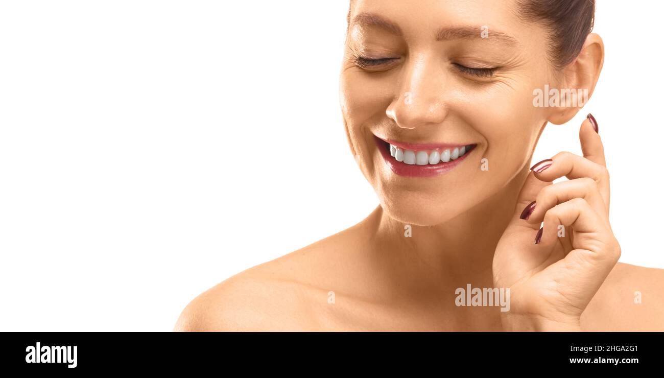 Skin care concept - close-up portrait of a 40 years old woman with closed eyes touching her skin. Isolated on white Stock Photo