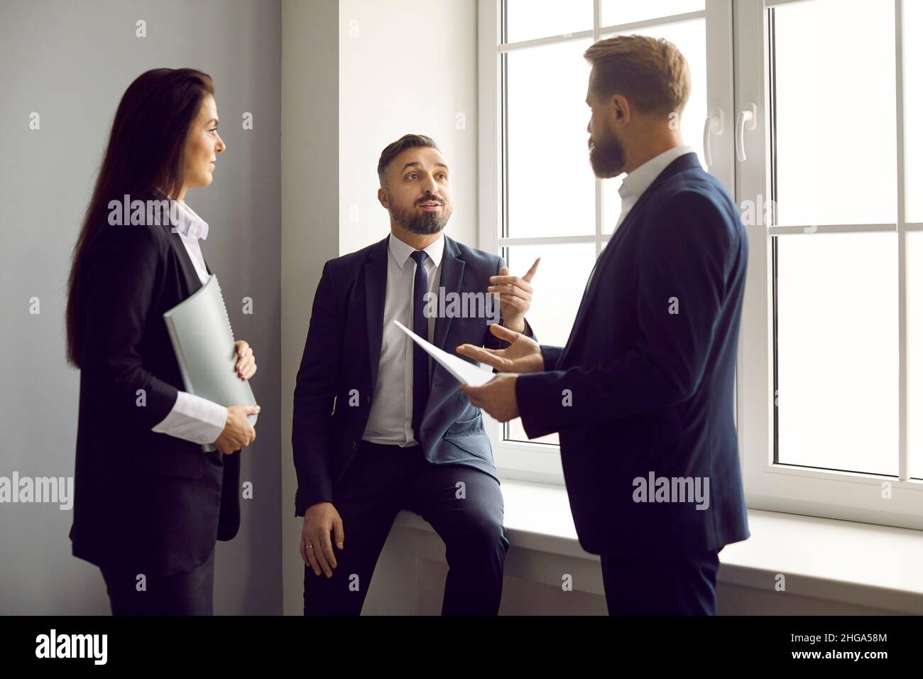 Team of business people standing in the office and discussing something work related Stock Photo