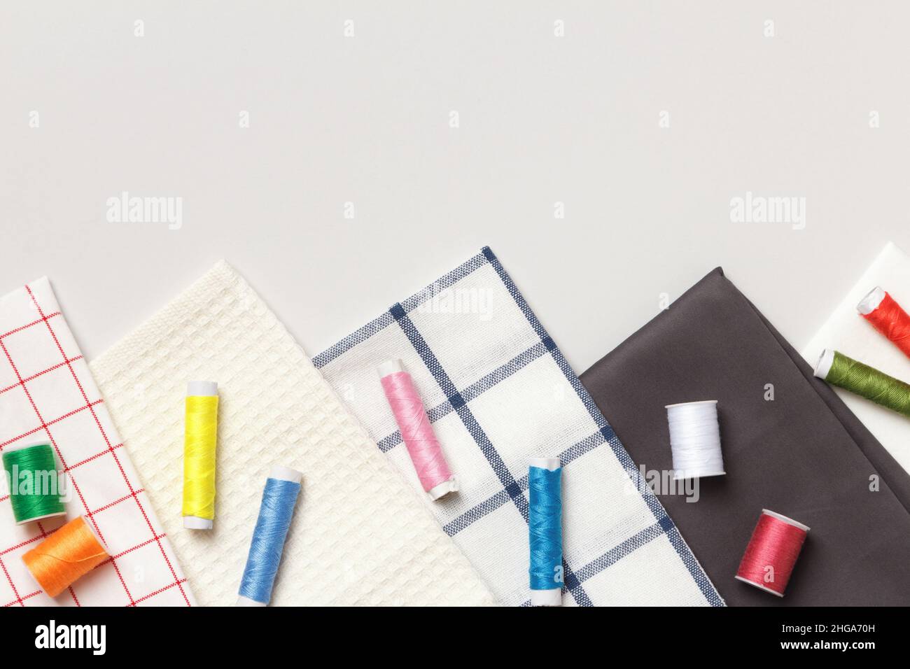 Fabric and threads on a gray background. Top view flat lay copy space Stock Photo
