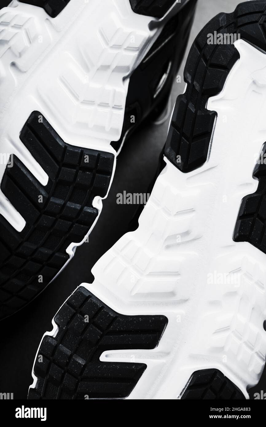 The black and white sole of trendy sports sneakers is a closeup in