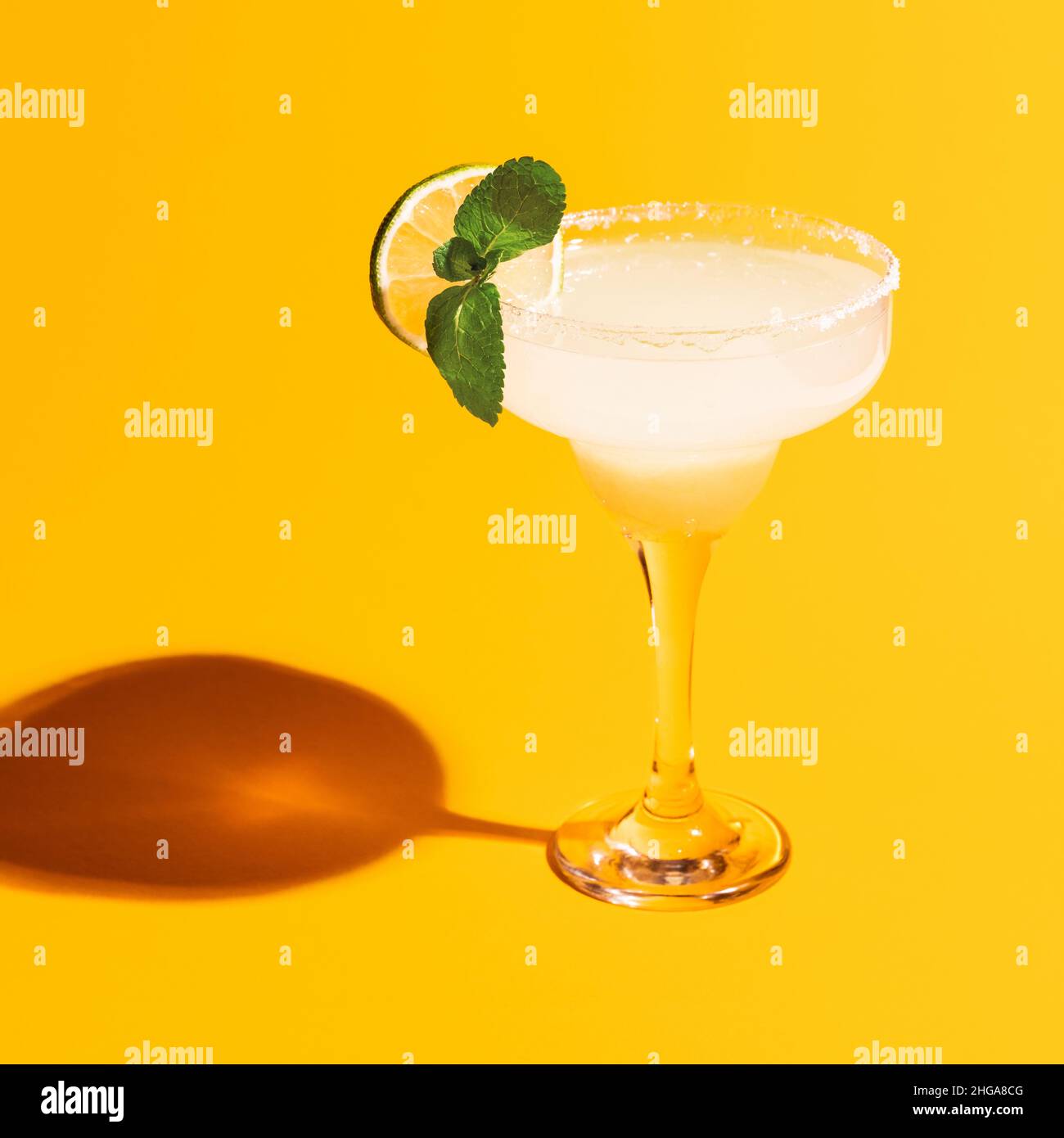 Margarita glass isolated on bright yellow neon background with shadow