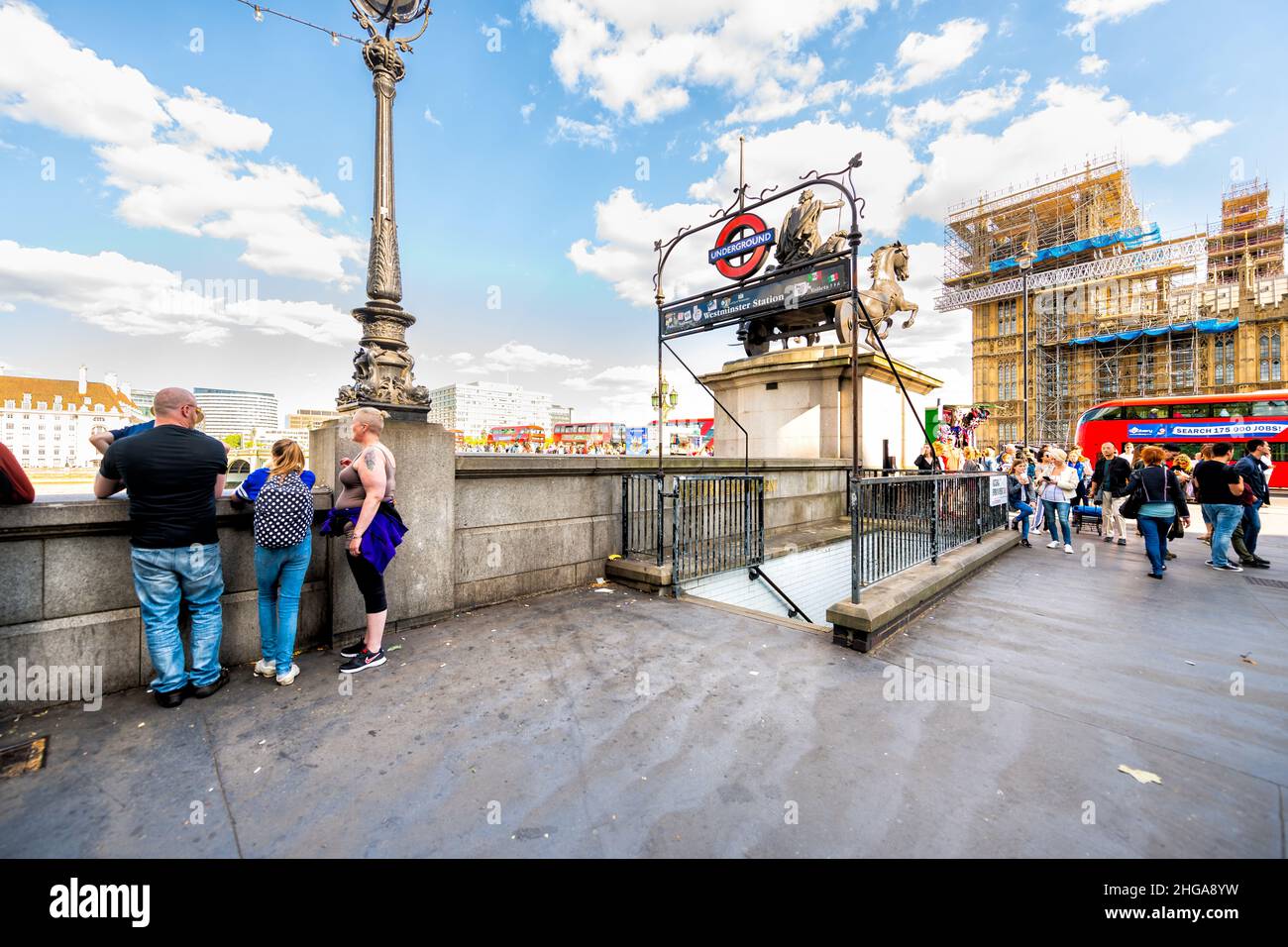 London, UK - June 21, 2018: Thames River embankment and sign for Westminster underground tube station in summer and construction scaffold on houses of Stock Photo