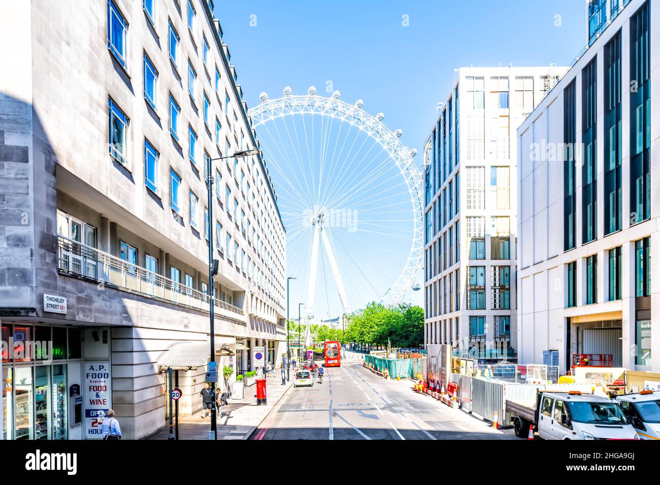 London, UK - June 22, 2018: Road alley street with London Eye Millennium ferris wheel by buildings near City Hall headquarters in South Bank on summer Stock Photo