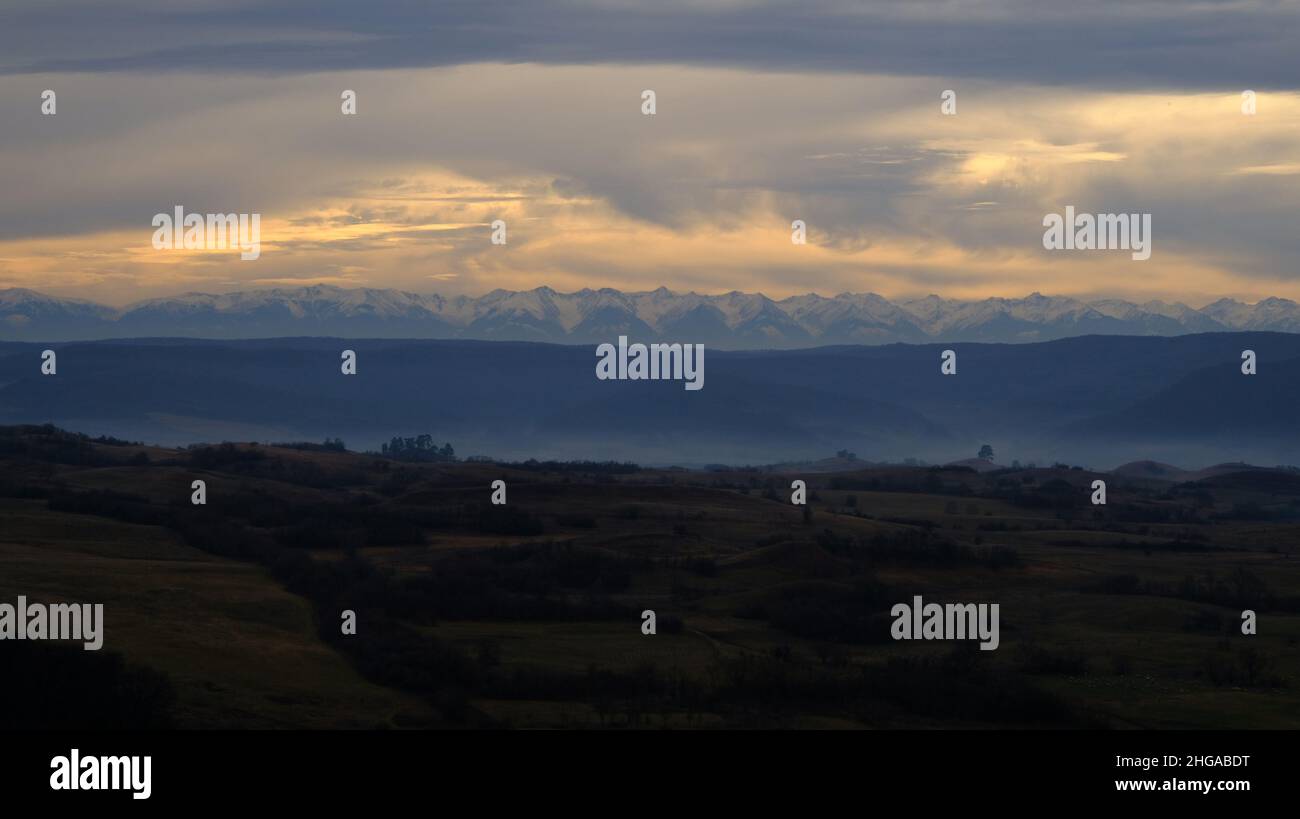 Carpathian mountains over the foggy field in mysterious Transylvania at dusk Stock Photo