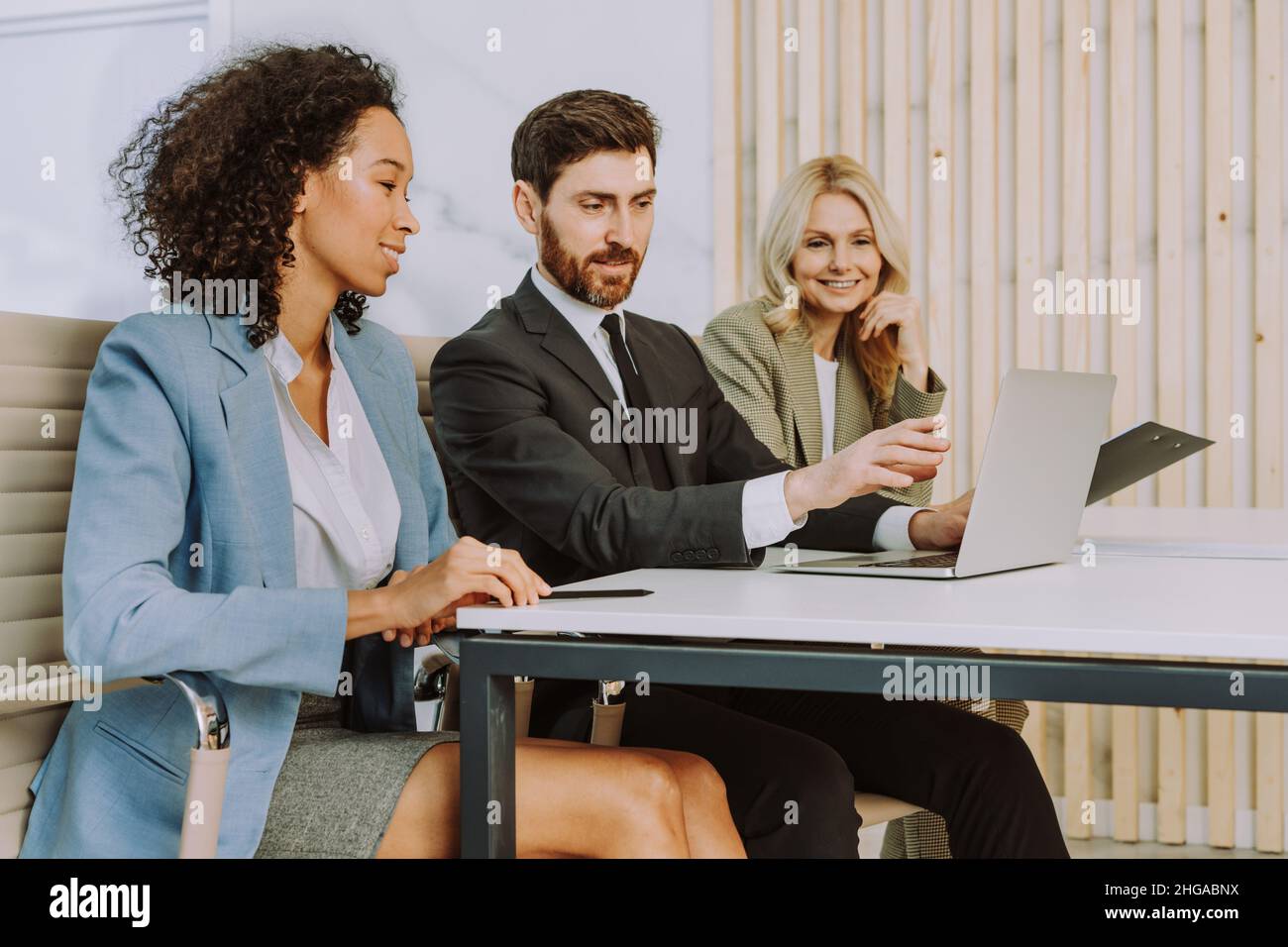 Multiracial group of businesspeople with elegant dress sitting at ...