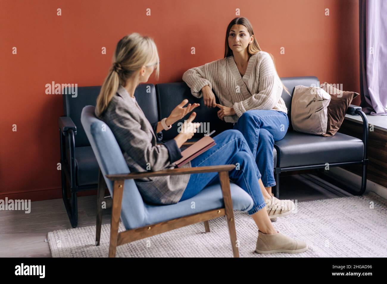 A female psychotherapist consults and gives advice and psychological support to a young woman. Stock Photo