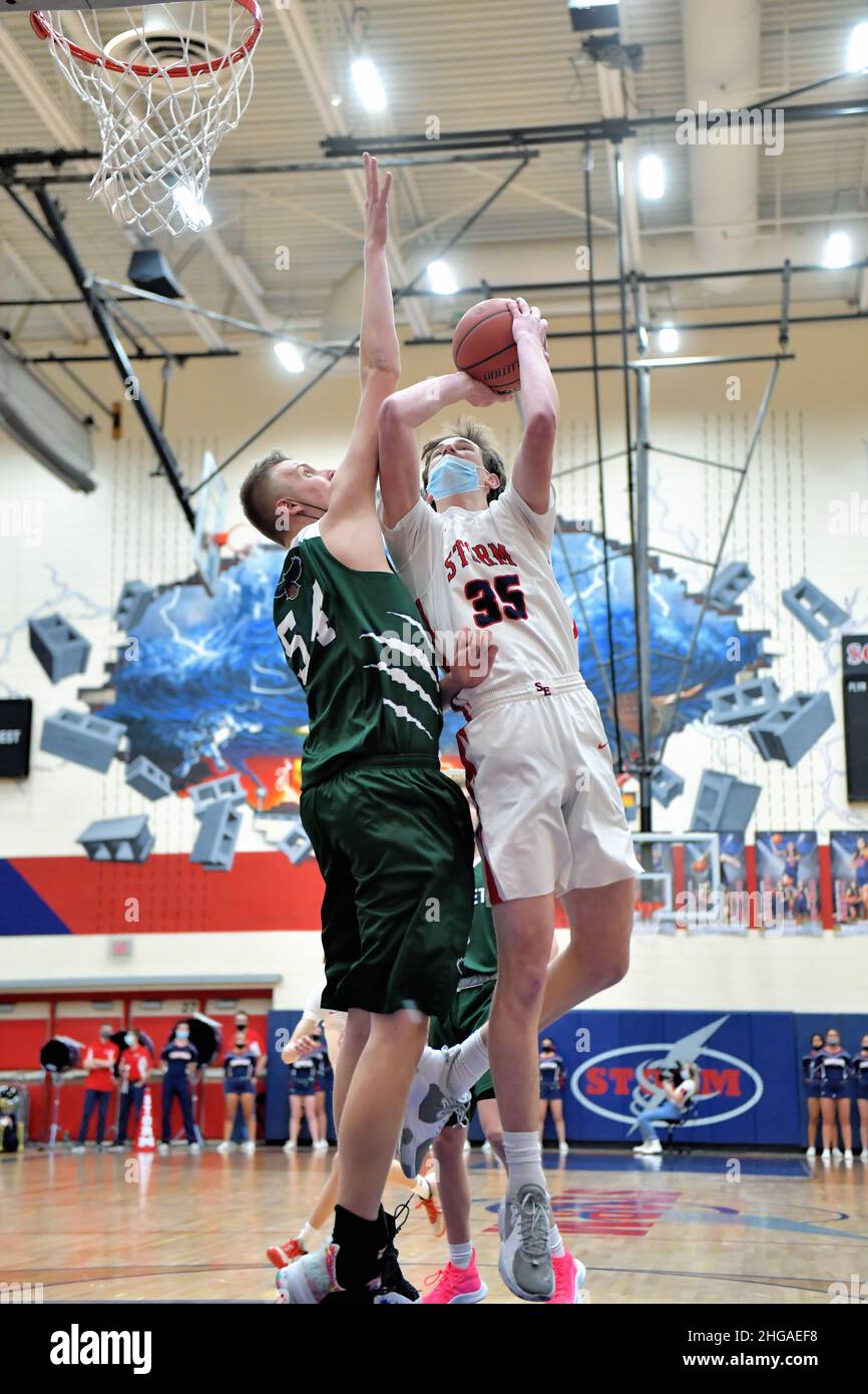 USA. High school forward attempting to shoot over an opposing center, left. Stock Photo