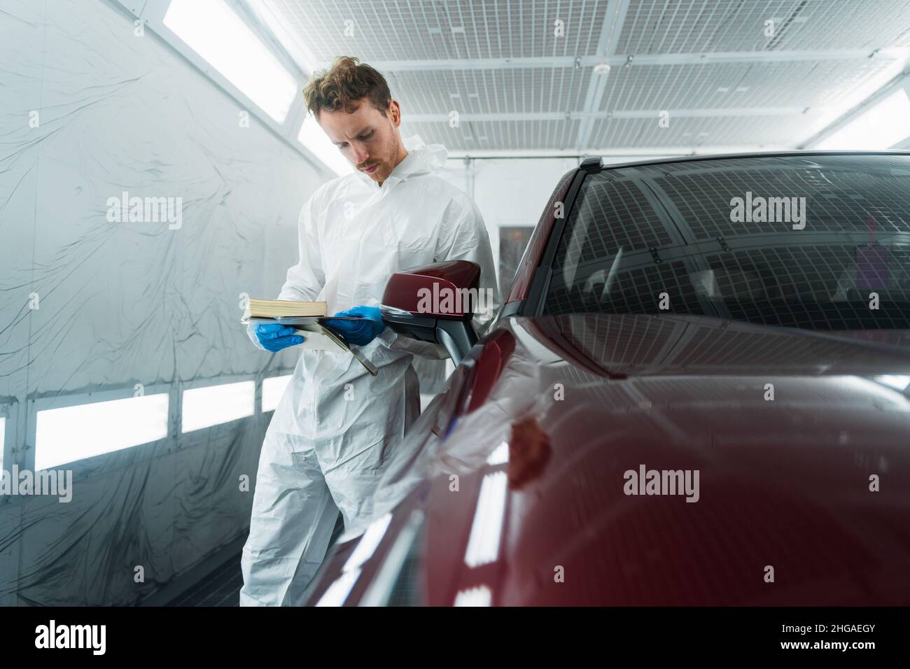 Auto colorist in the painting chamber selects the color of the car ...