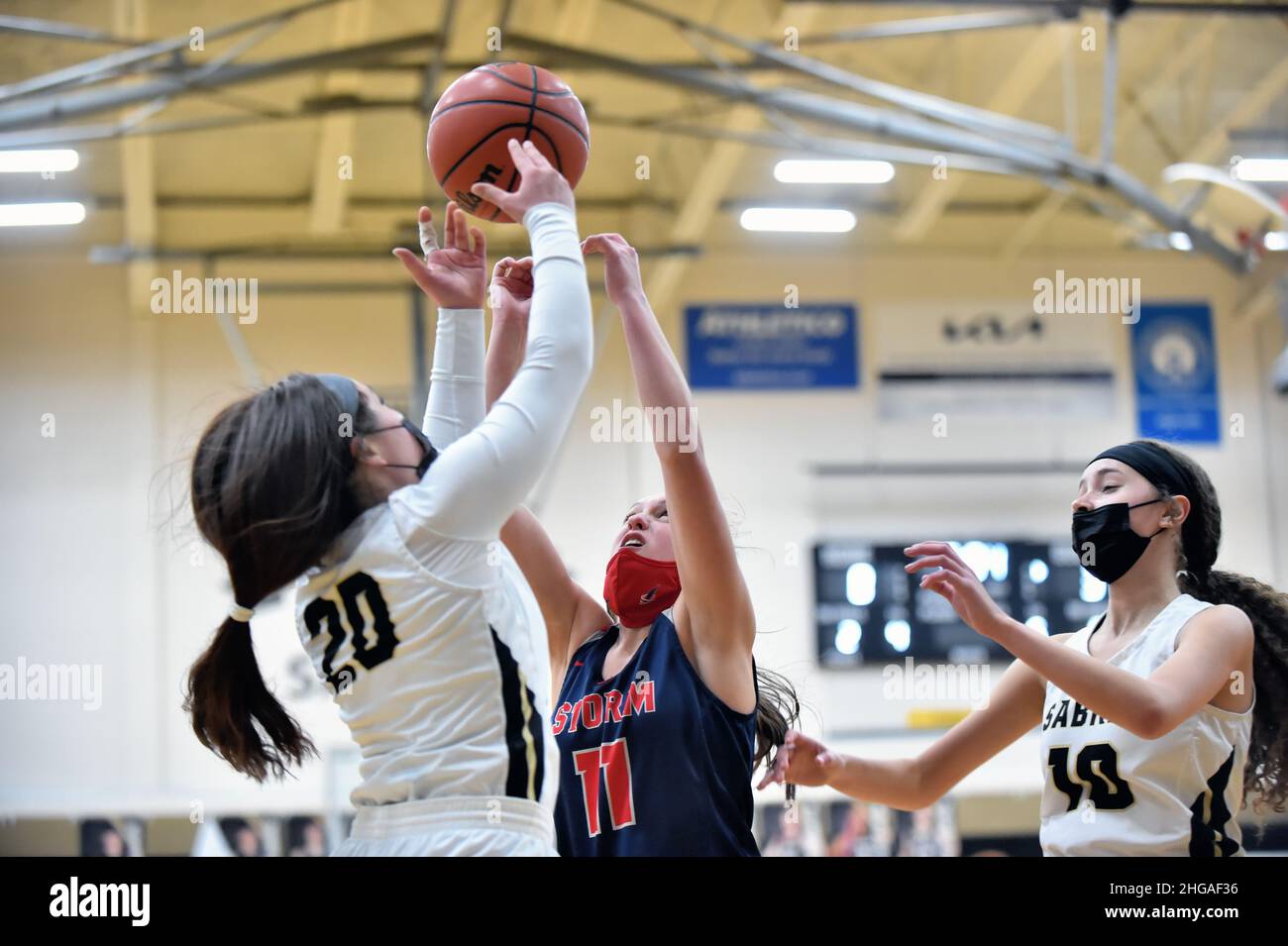 USA. While sandwiched between two opponents, a player attempted to secure a rebound. Stock Photo