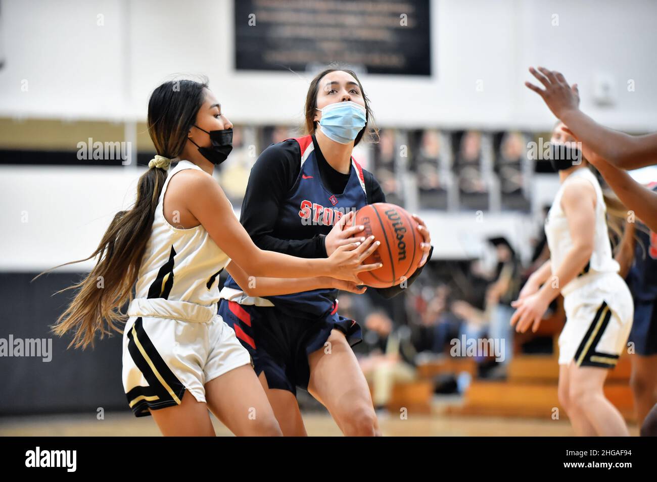 USA. After driving into the paint, a player encounters a defender who challenged her claim for possession of the ball. Stock Photo