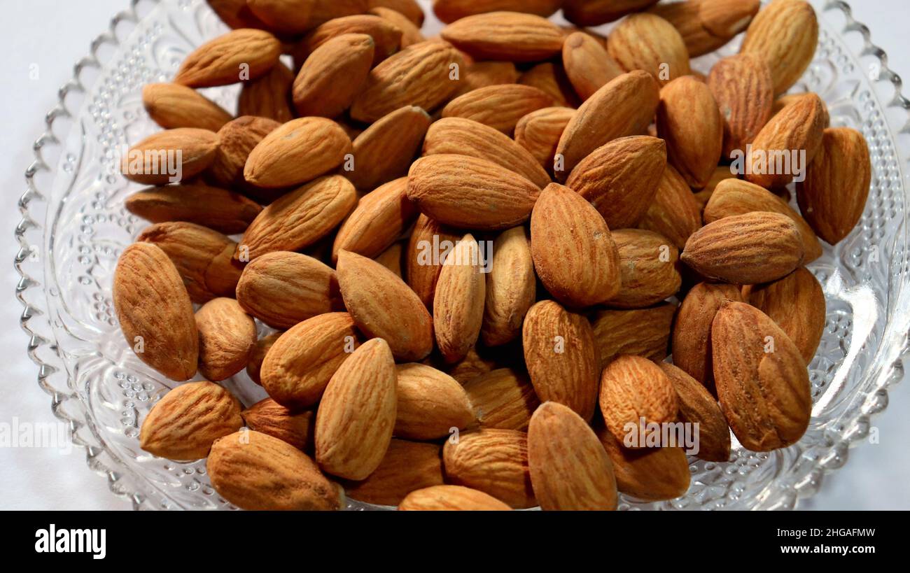 Healthy dry food for break fast,Almond on a plate with white background,healthy food for control blood sugar and cholesterol level Stock Photo
