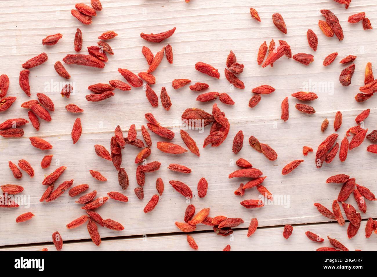 Dried organic goji berries on a wooden table, macro, top view. Stock Photo