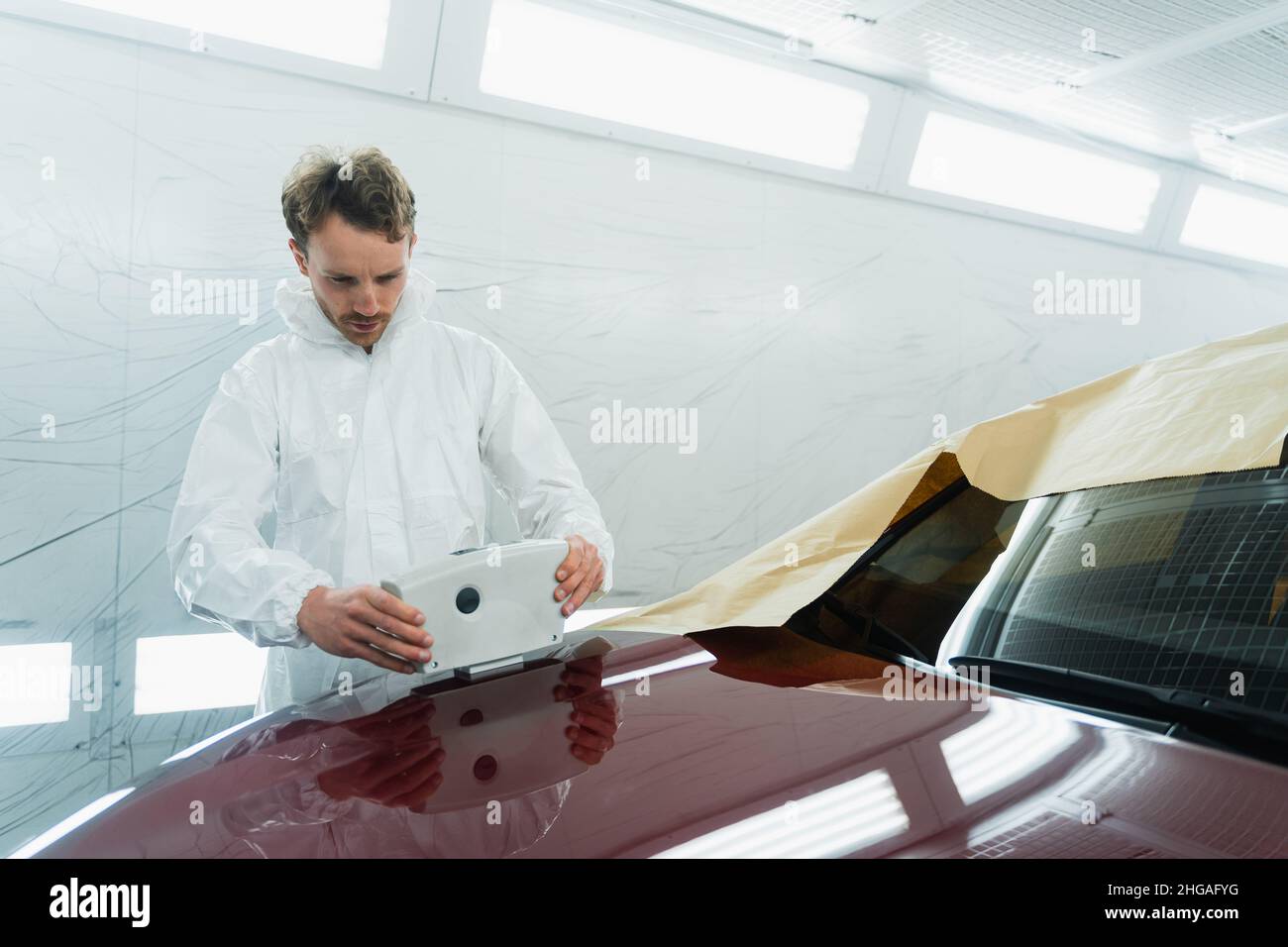 Colourist man selecting color of car body with paint matching scanner