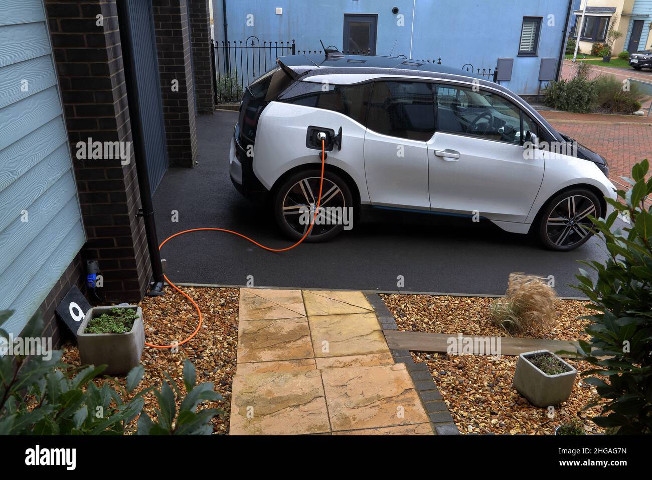 Home charging being done from the household electric supply using an external socket and plug. Stock Photo