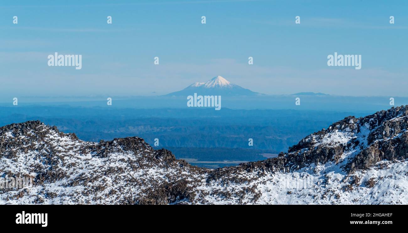Snow covered Mount Taranaki, or Egmont, an active volcano, viewed from far away in tongariro national park, New Zealand. Stock Photo