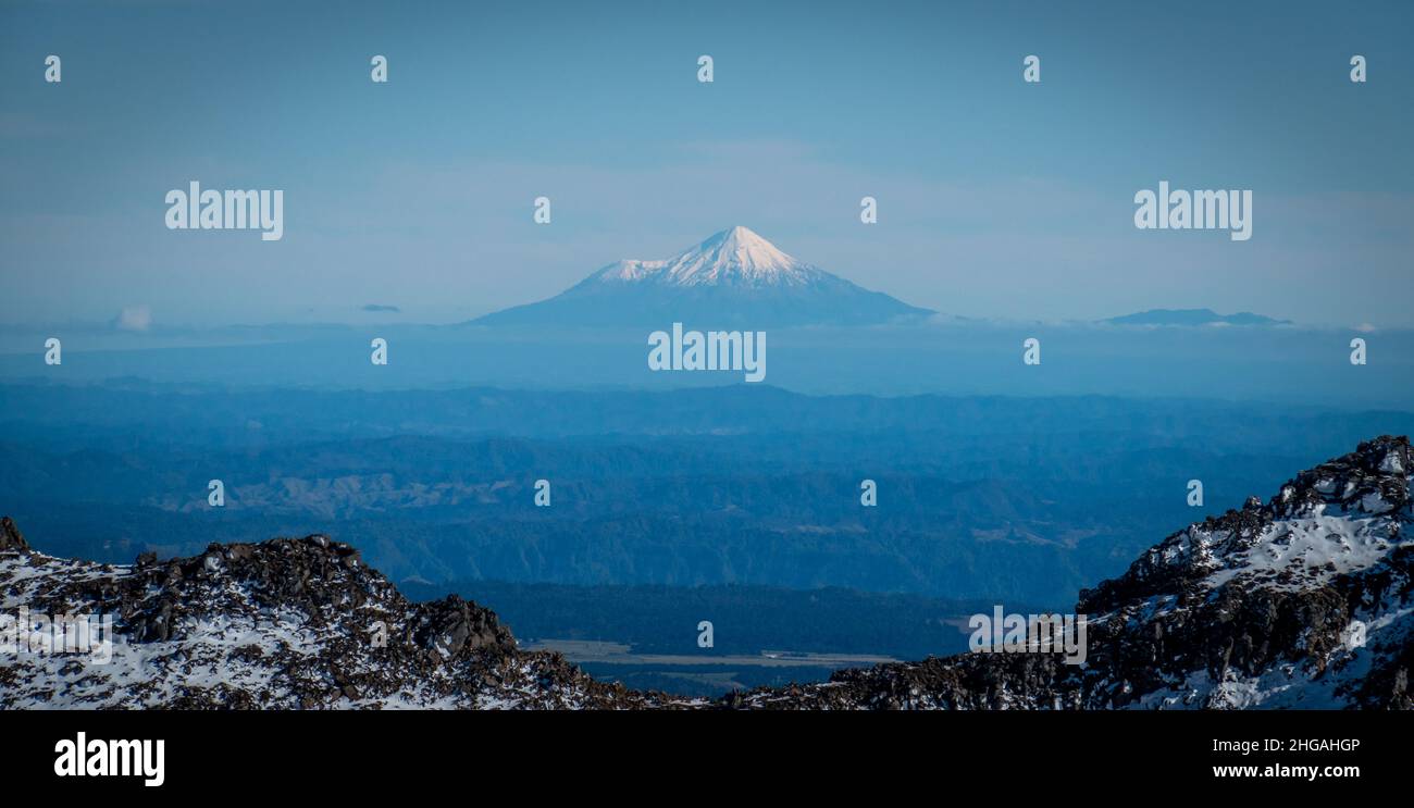 Snow covered Mount Taranaki, or Egmont, an active volcano, viewed from far away in tongariro national park, New Zealand. Stock Photo