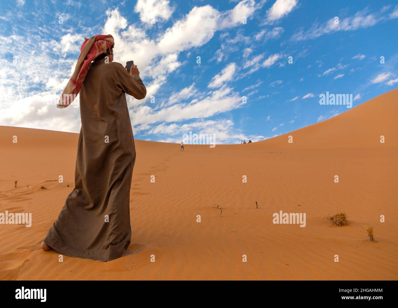 Saudi man taking picture of a Rub al Khali dune, Najran Province, Thar, Saudi Arabia Stock Photo