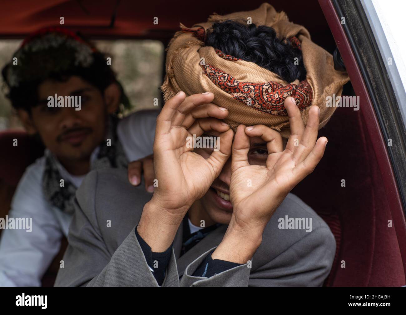 Young man in a car mimics the photographer, Asir province, Sarat Abidah, Saudi Arabia Stock Photo