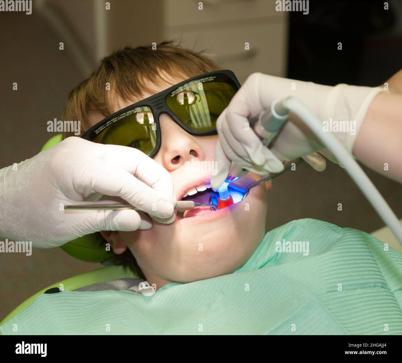 Boy in dental office during hardening of dental filling Stock Photo