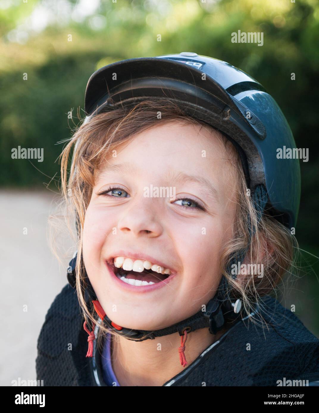 Happy little girl in helmet for horseriding Stock Photo