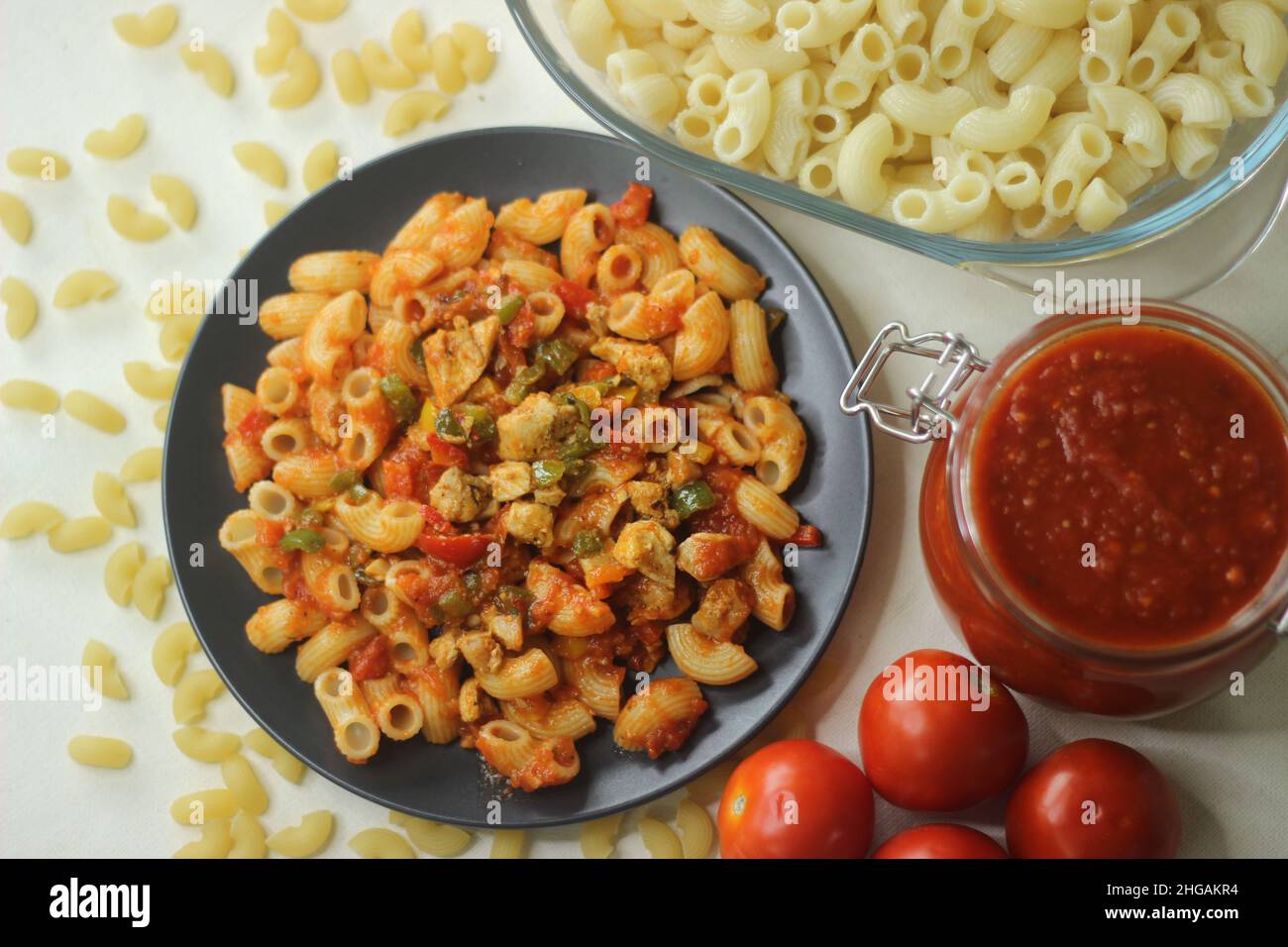 Red sauce macaroni pasta, shot with red tomatoes and red sauce in a jar