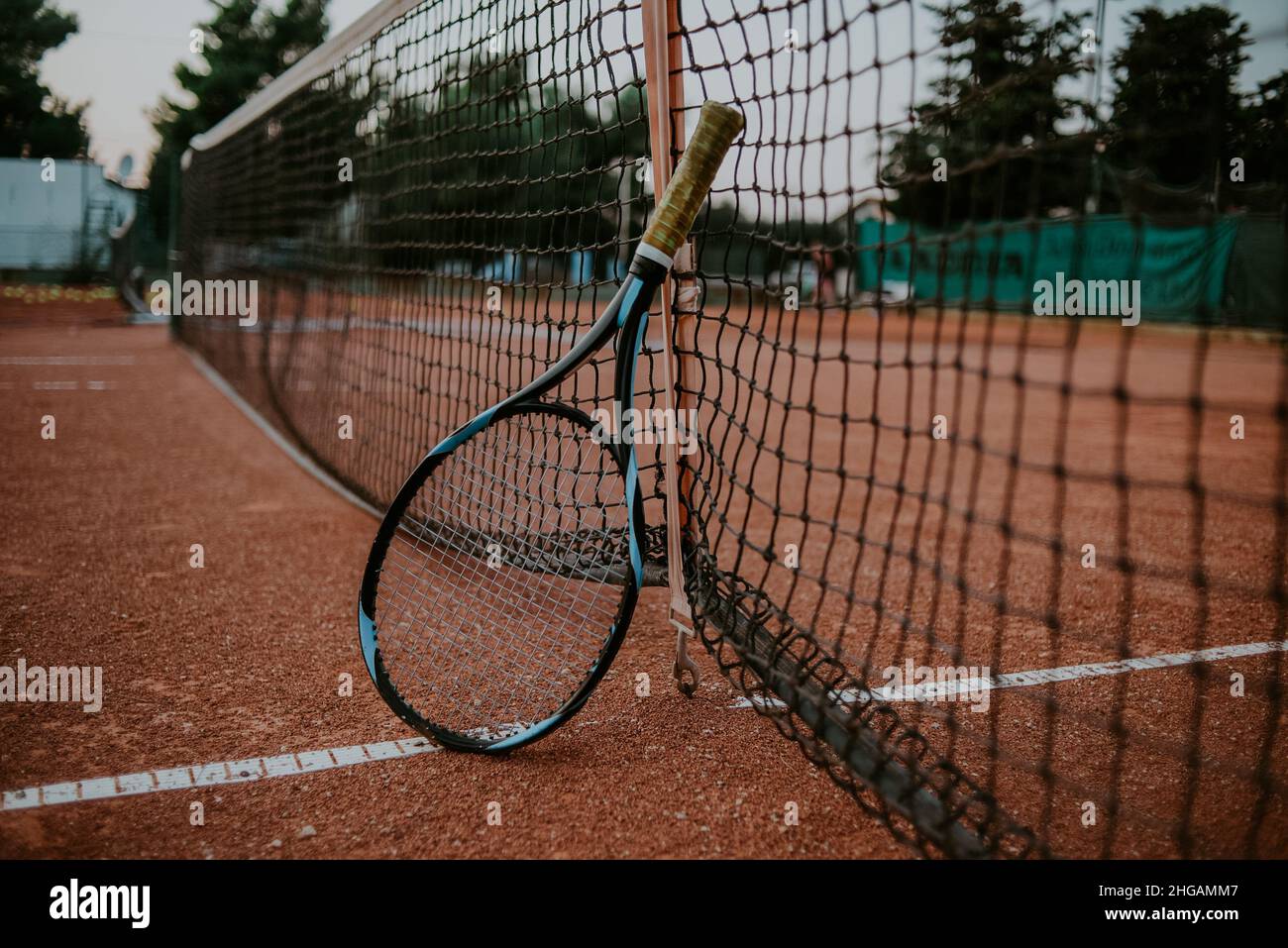 Tennis racket and tennis net. Large outdoor tennis field, sports, healthy lifestyle Stock Photo