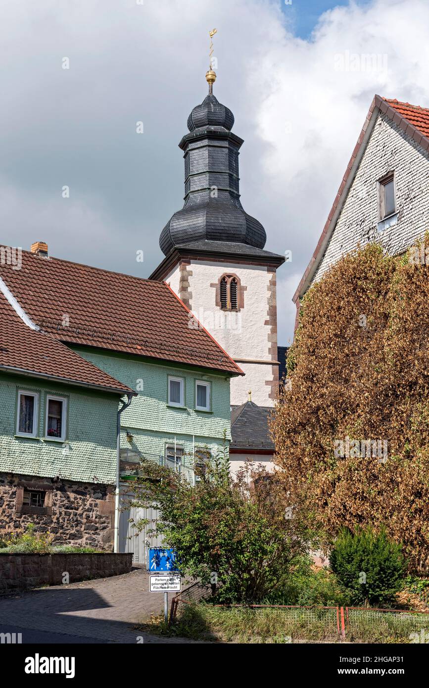 Bell tower of the Catholic Church of St. James between old clapboard houses, Herbstein, Vogelsberg, Hesse, Germany Stock Photo