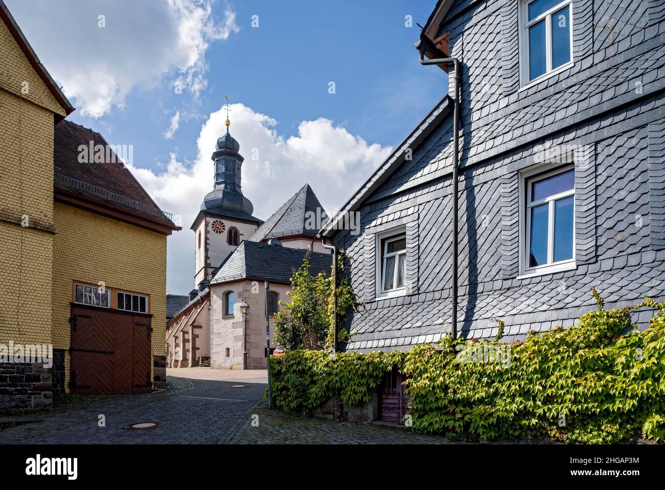 St. James Catholic Church among old clapboard houses made of wood and slate, Herbstein, Vogelsberg, Hesse, Germany Stock Photo