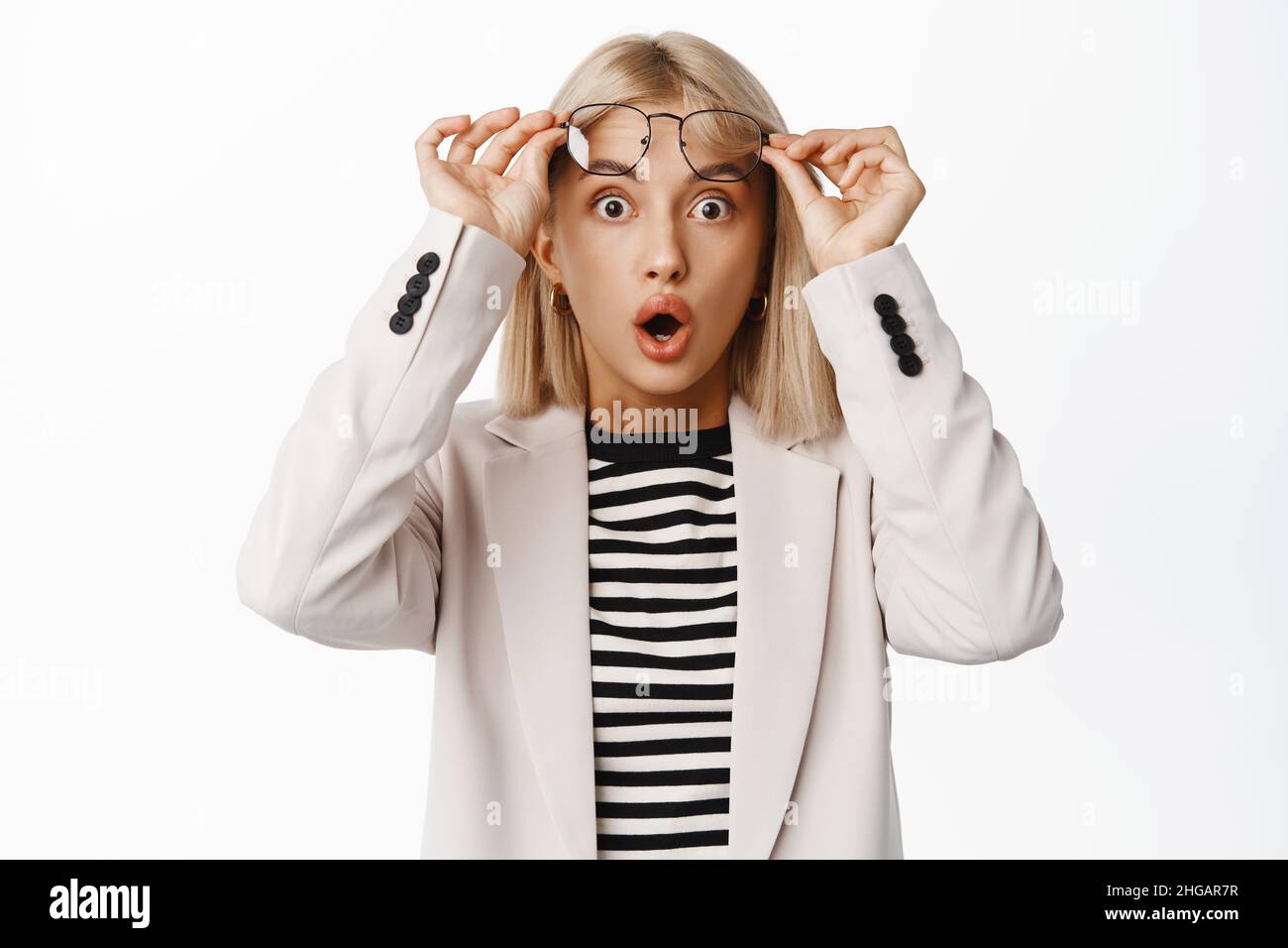 Portrait Of Shocked Young Woman Takes Off Glasses And Gasping Impressed