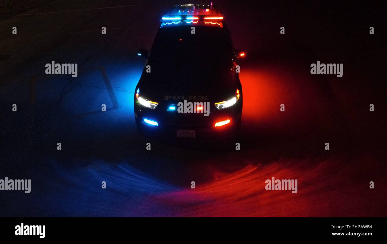 Police SUV at night with lights on Stock Photo