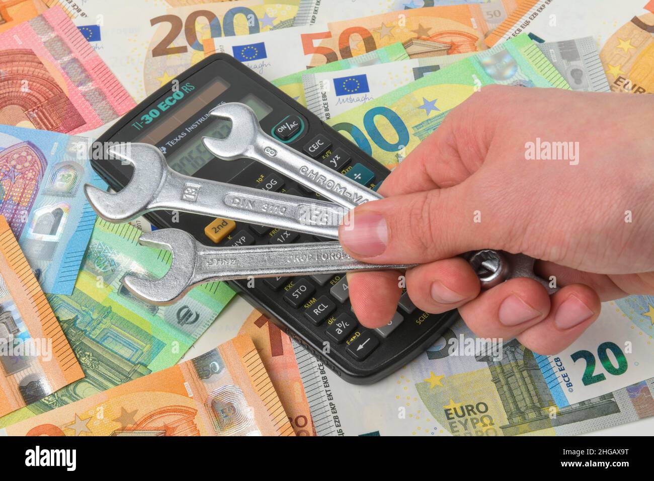 Spanner, money, euro notes, calculator, symbol photo craftsman costs, studio shot Stock Photo