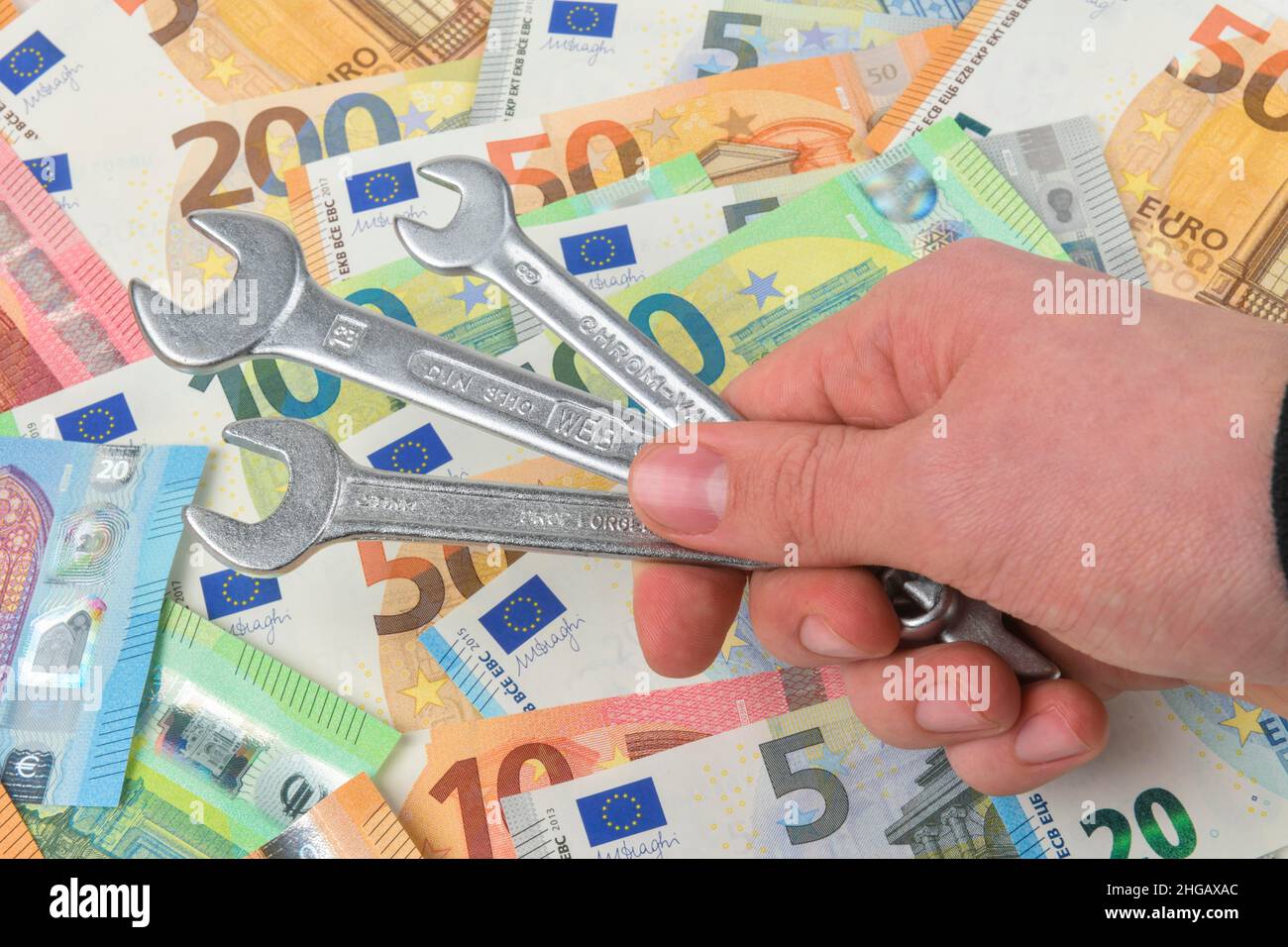 Spanner, money, euro notes, symbol photo craftsman costs, studio shot Stock Photo