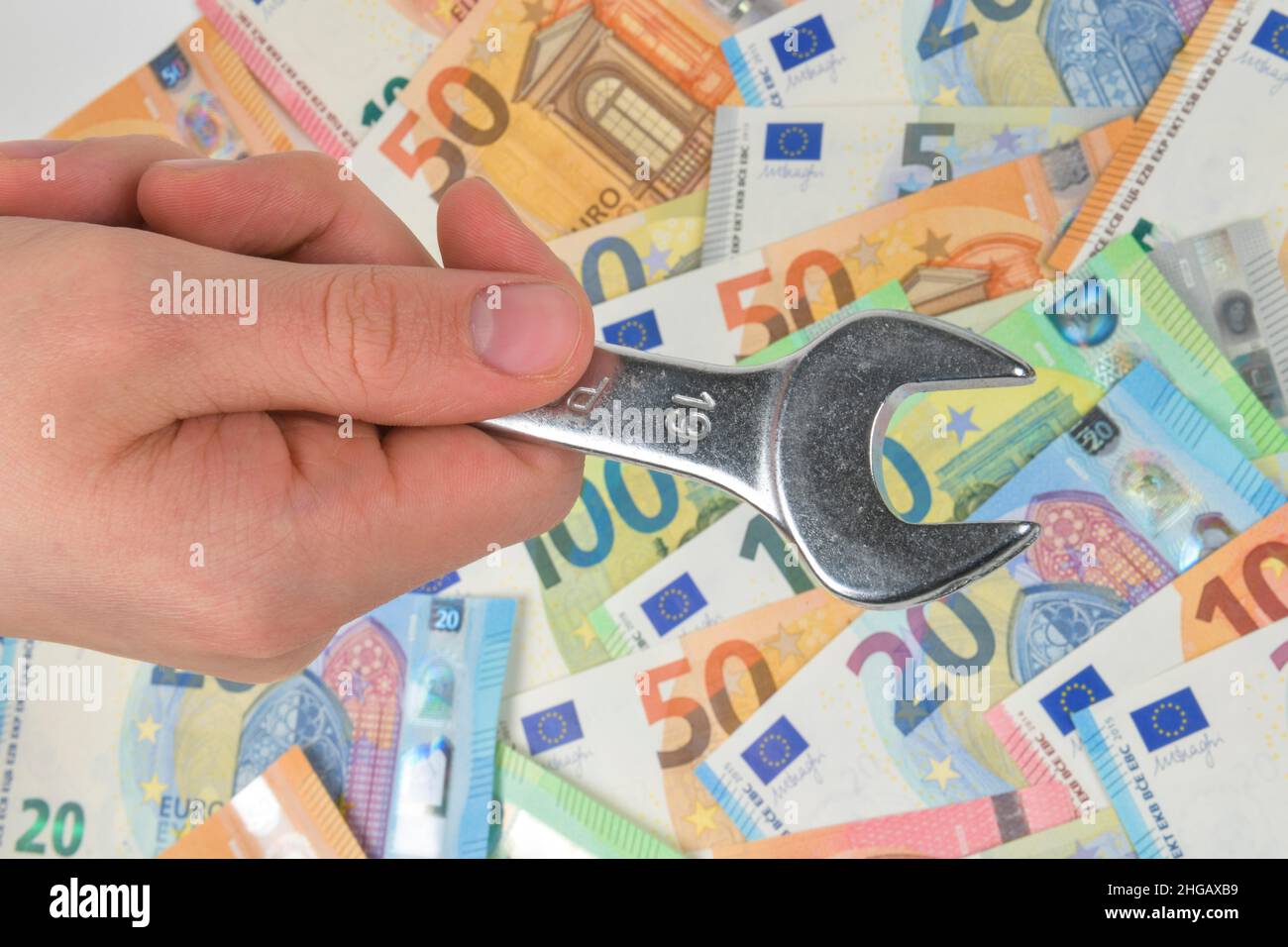 wrench, money, euro notes, symbol photo craftsman costs, studio shot Stock Photo