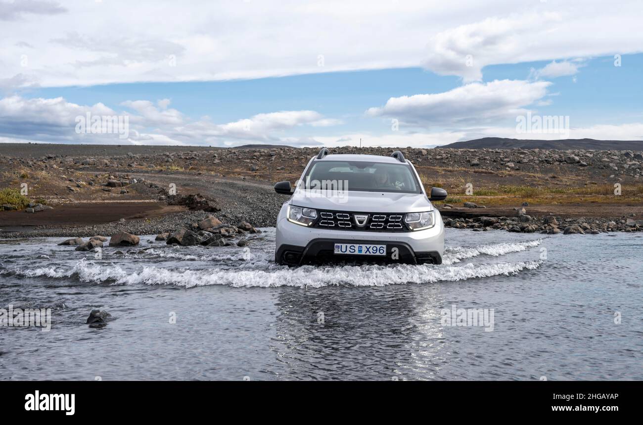 Dacia Duster 4x4 car crossing a river, ford, gravel road, barren
