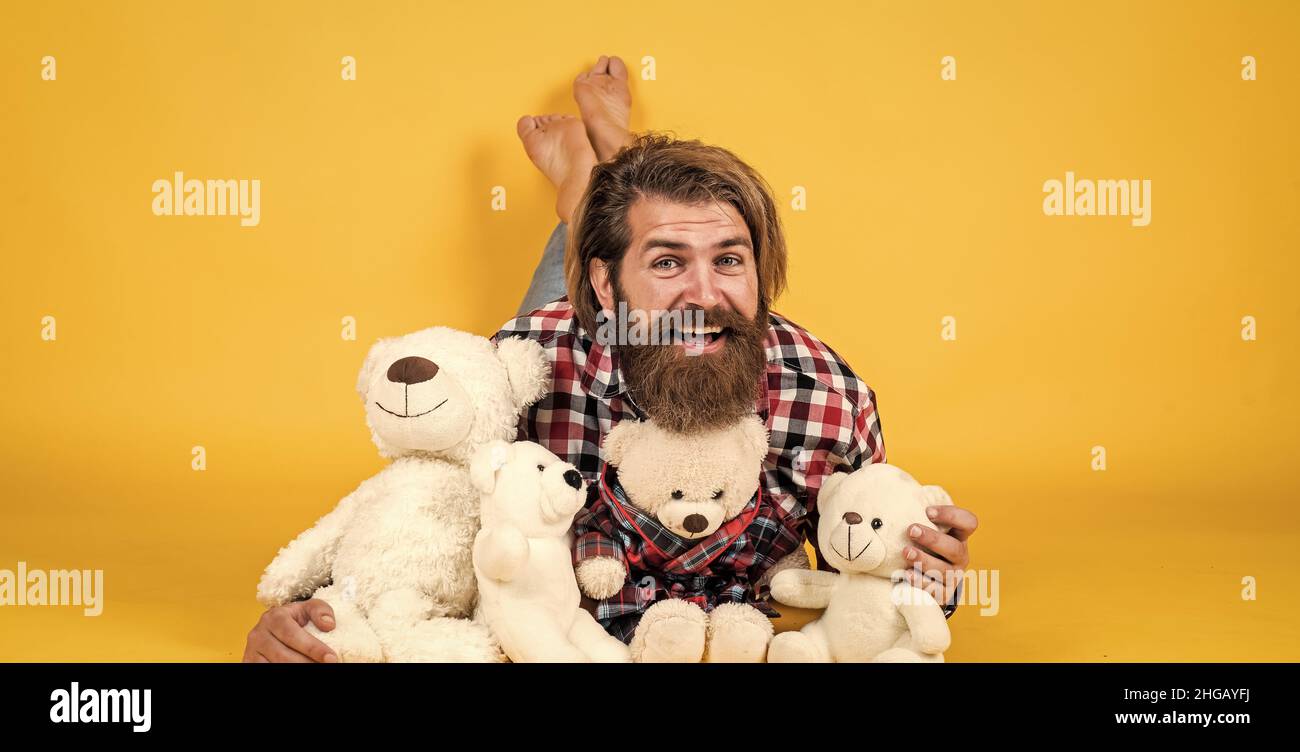 brutal bearded man wear checkered shirt having lush beard and moustache with teddy bear toy, happy birthday Stock Photo